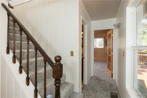 a view of a hallway with wooden floor and staircase