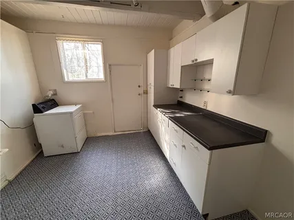 a kitchen with white cabinets and white appliances