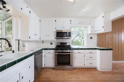 a white kitchen with granite countertop stainless steel appliances