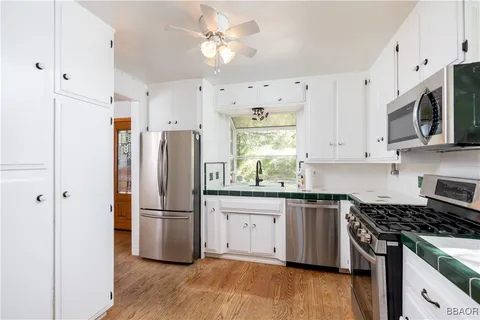 a kitchen with stainless steel appliances granite countertop a stove a refrigerator a microwave and cabinets