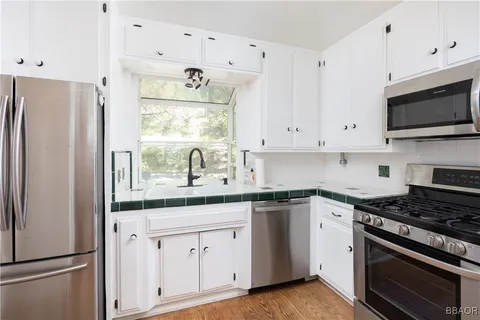 a kitchen with cabinets stainless steel appliances and a window