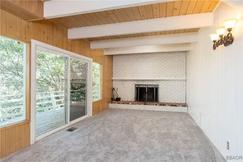 a view of an empty room with a fireplace and a window