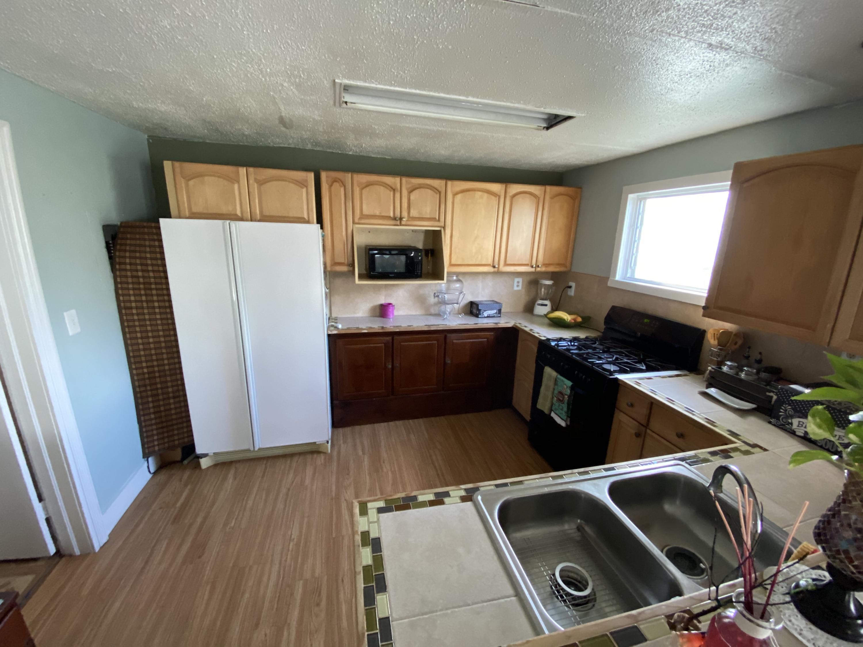 927 Catherine Street Key West, FL 33040 - Photo 18 of 29 a kitchen with a refrigerator sink and wooden floor