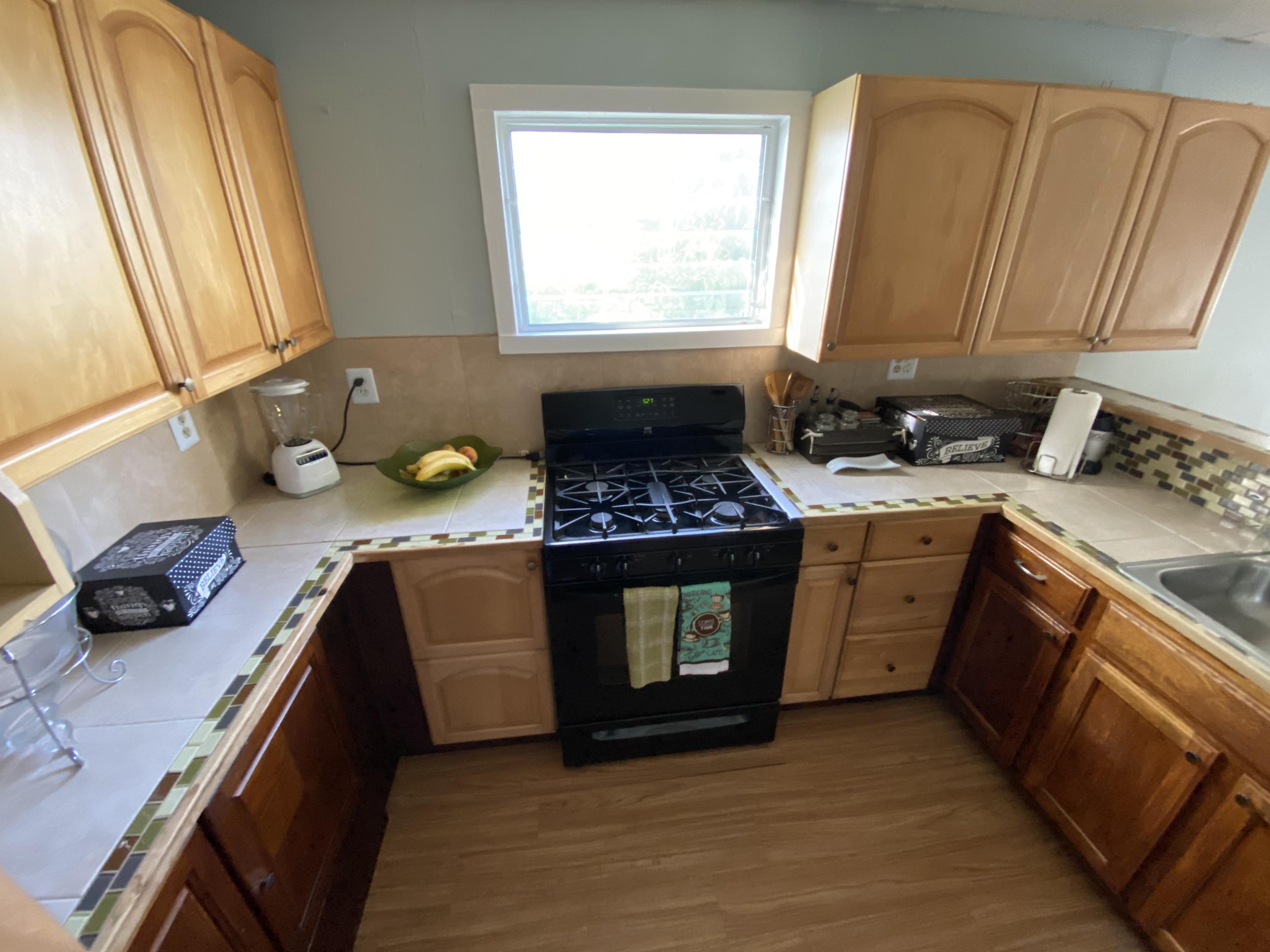 927 Catherine Street Key West, FL 33040 - Photo 20 of 29 a kitchen with a sink a stove and cabinets