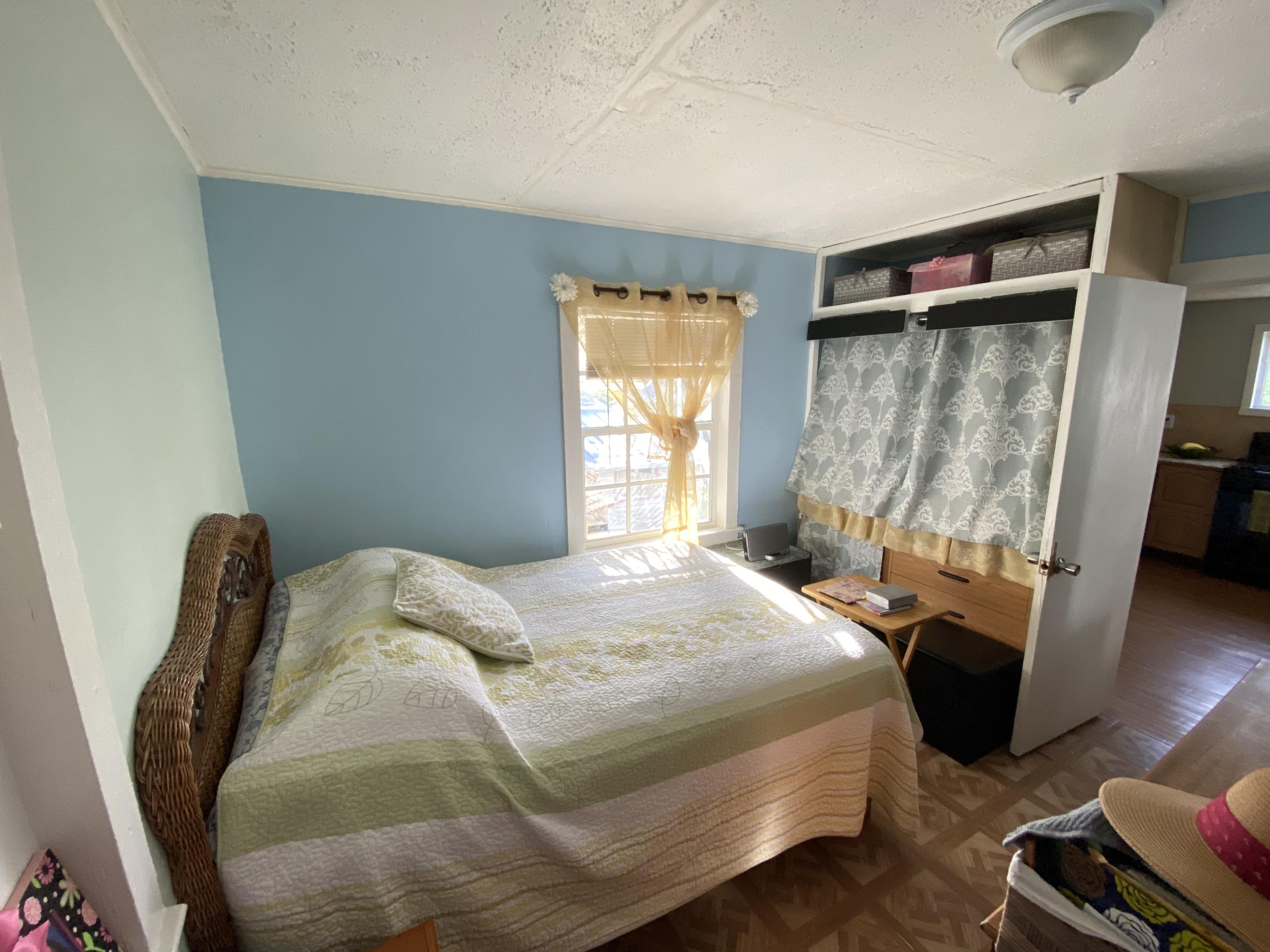 927 Catherine Street Key West, FL 33040 - Photo 28 of 29 a bedroom with a bed and wooden floor