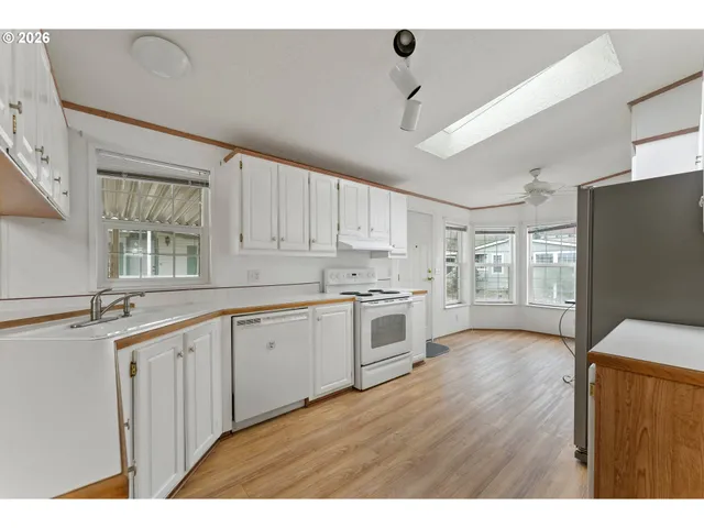 a kitchen with granite countertop white cabinets and white appliances