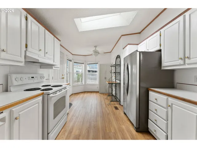 a kitchen with stainless steel appliances granite countertop a refrigerator a stove and a sink