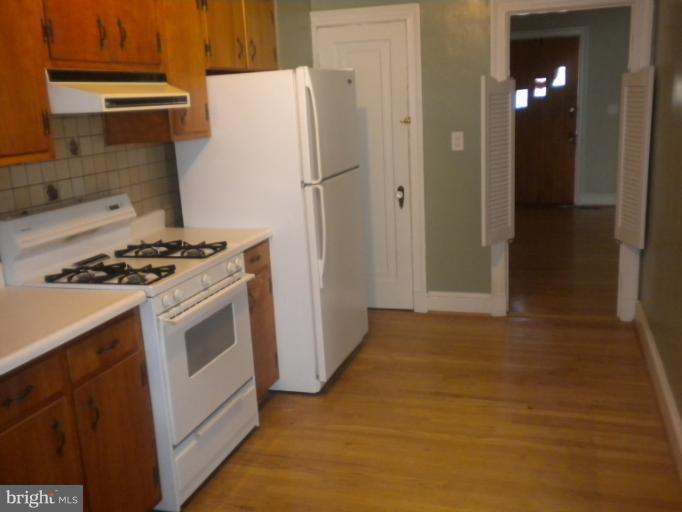 305 Hopkins Road Baltimore, MD 21212 - Photo 12 of 30 a kitchen with a stove a refrigerator and a cabinets