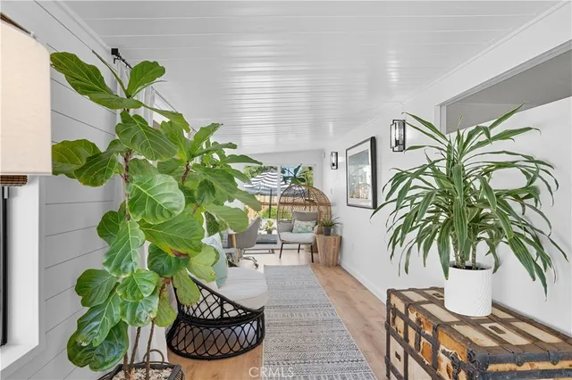 a view of a hallway with wooden floor and cabinet