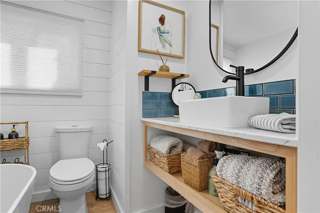 a view of a patio with couches table and chairs under an umbrella