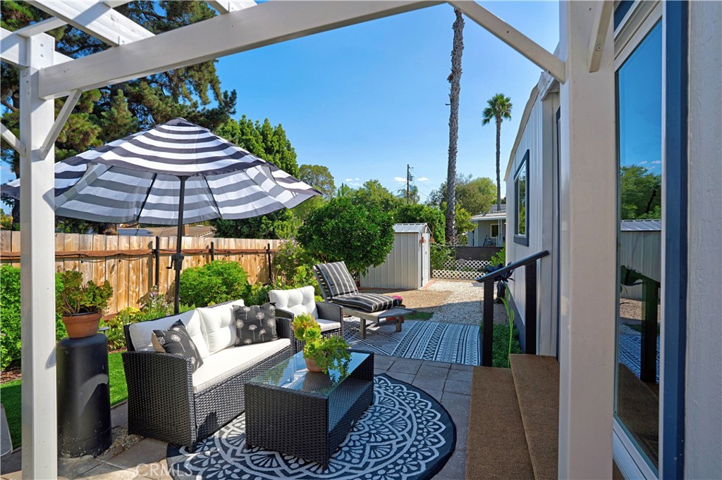 1120 East Mission Road, Unit 33 Fallbrook, CA 92028 - Photo 28 of 47 a view of a patio with couches table and chairs under an umbrella