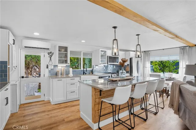 a kitchen with stainless steel appliances kitchen island granite countertop a stove a sink and a refrigerator