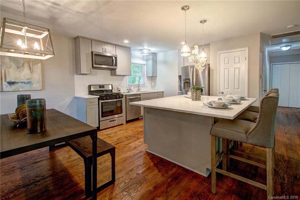 7439 Watercrest Road Charlotte, NC 28210 - Photo 1 of 28 a kitchen with a table chairs stove and cabinets
