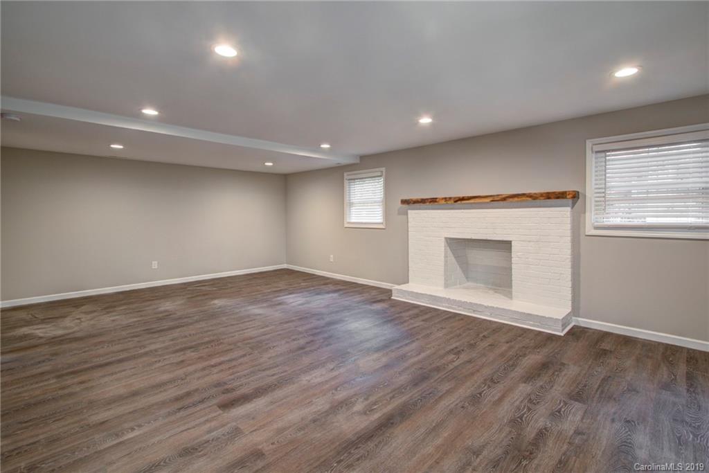 7439 Watercrest Road Charlotte, NC 28210 - Photo 22 of 28 an empty room with wooden floor and a fireplace