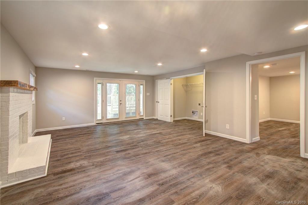 7439 Watercrest Road Charlotte, NC 28210 - Photo 23 of 28 an empty room with wooden floor and a fireplace