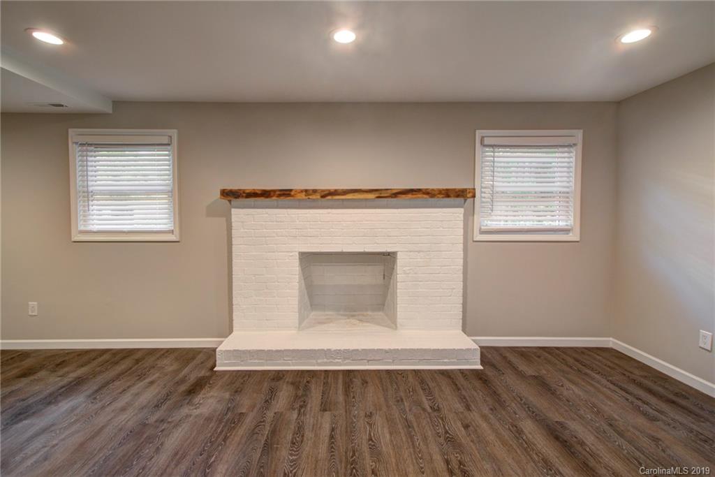 7439 Watercrest Road Charlotte, NC 28210 - Photo 24 of 28 an empty room with a fireplace and wooden floor