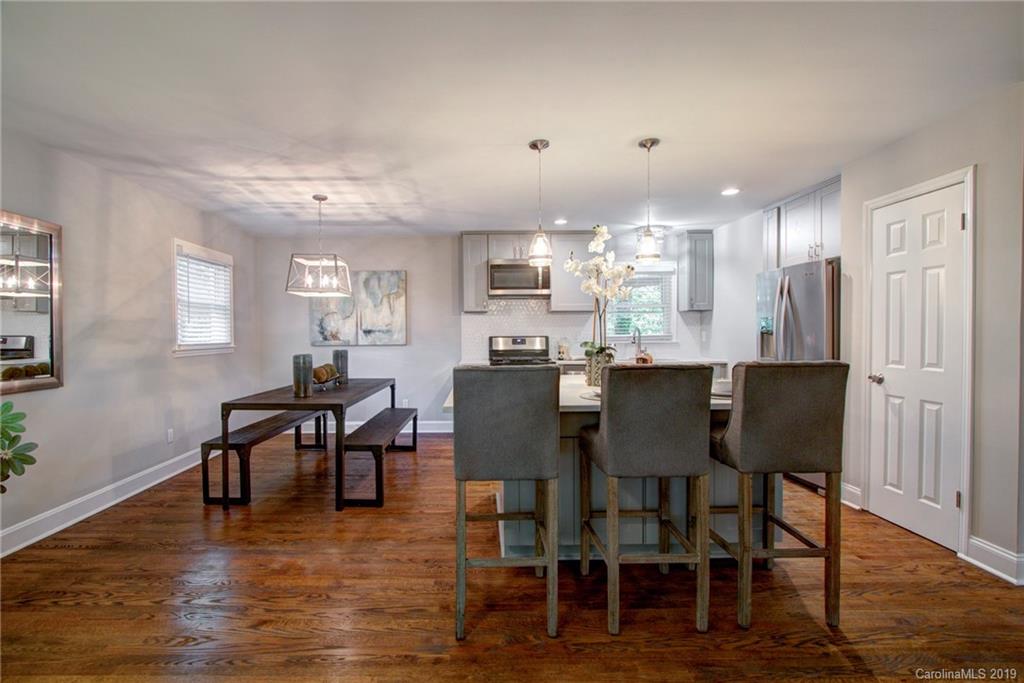 7439 Watercrest Road Charlotte, NC 28210 - Photo 8 of 28 a dining room with furniture wooden floor a rug and a painting