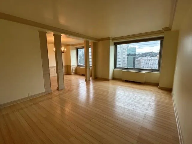a dining room with chandelier and wooden floor