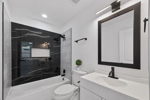 a bathroom with a sink toilet and shower