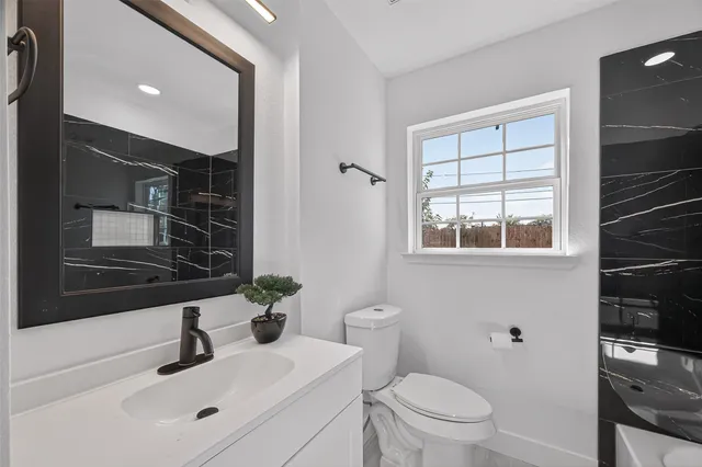 a bathroom with a sink toilet a mirror and shower