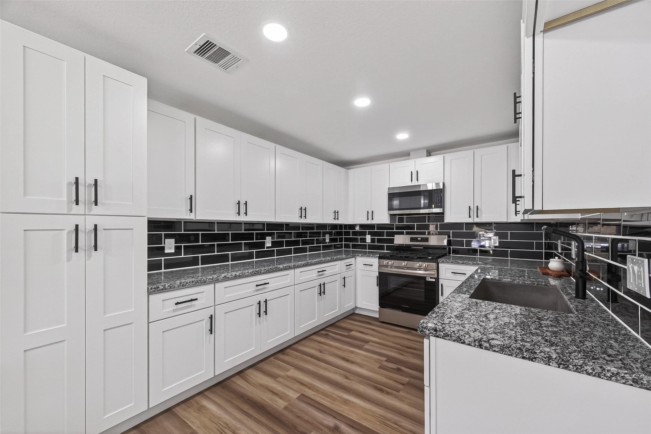 3112 Hays Street Pasadena, TX 77503 - Photo 3 of 22 a kitchen with stainless steel appliances granite countertop a stove sink and cabinets