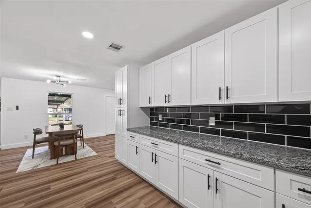 a kitchen with granite countertop a sink a stove and cabinets