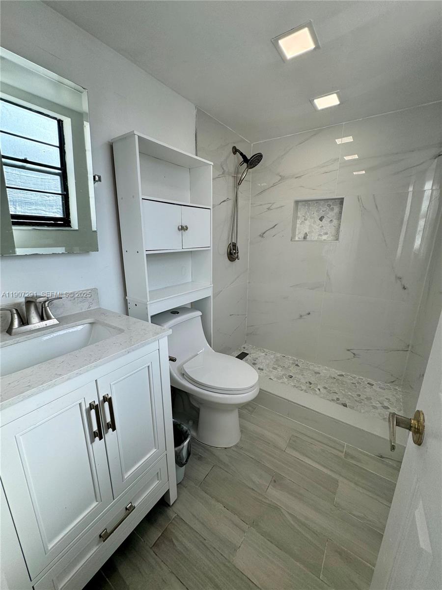 18250 Mediterranean Boulevard, Unit 1508 Hialeah, FL 33015 - Photo 18 of 26 a bathroom with a sink a toilet and a mirror