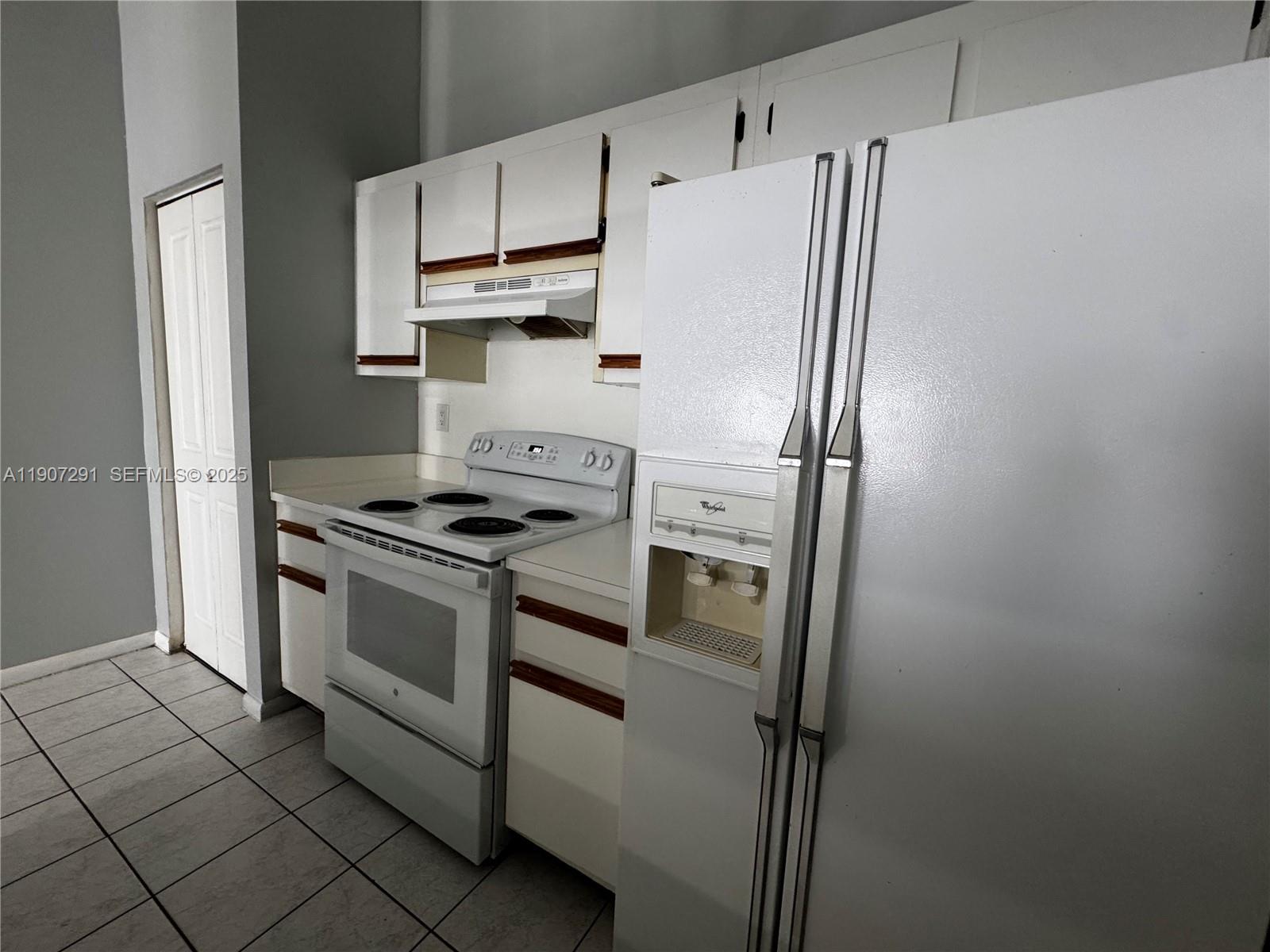 18250 Mediterranean Boulevard, Unit 1508 Hialeah, FL 33015 - Photo 7 of 26 a white refrigerator freezer and a stove sitting inside of a kitchen