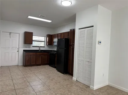 a kitchen with granite countertop a refrigerator and a sink