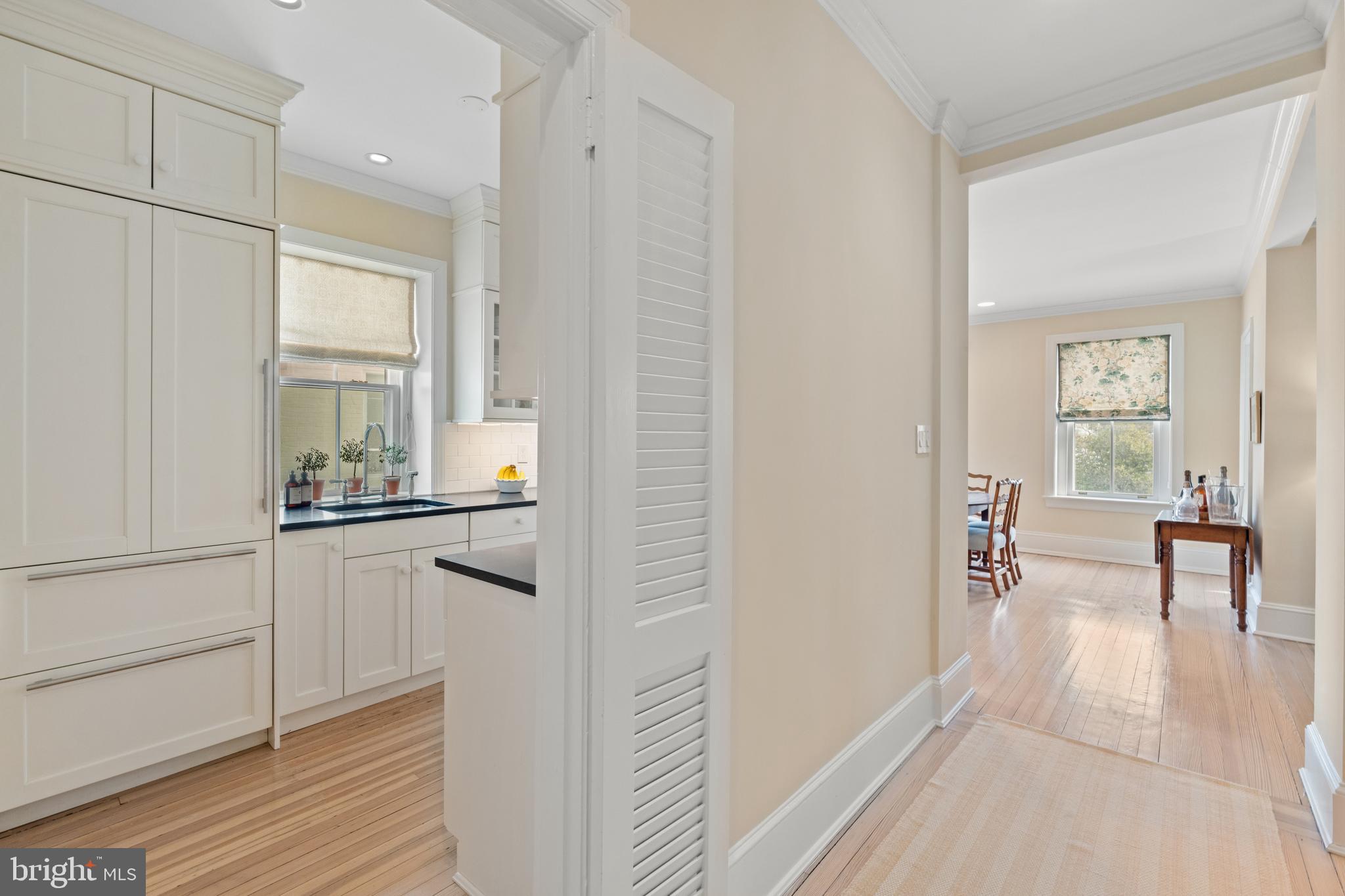 1657 31st Street Northwest, Unit 206 Washington, DC 20007 - Photo 3 of 26 a kitchen with white cabinets and wooden floor