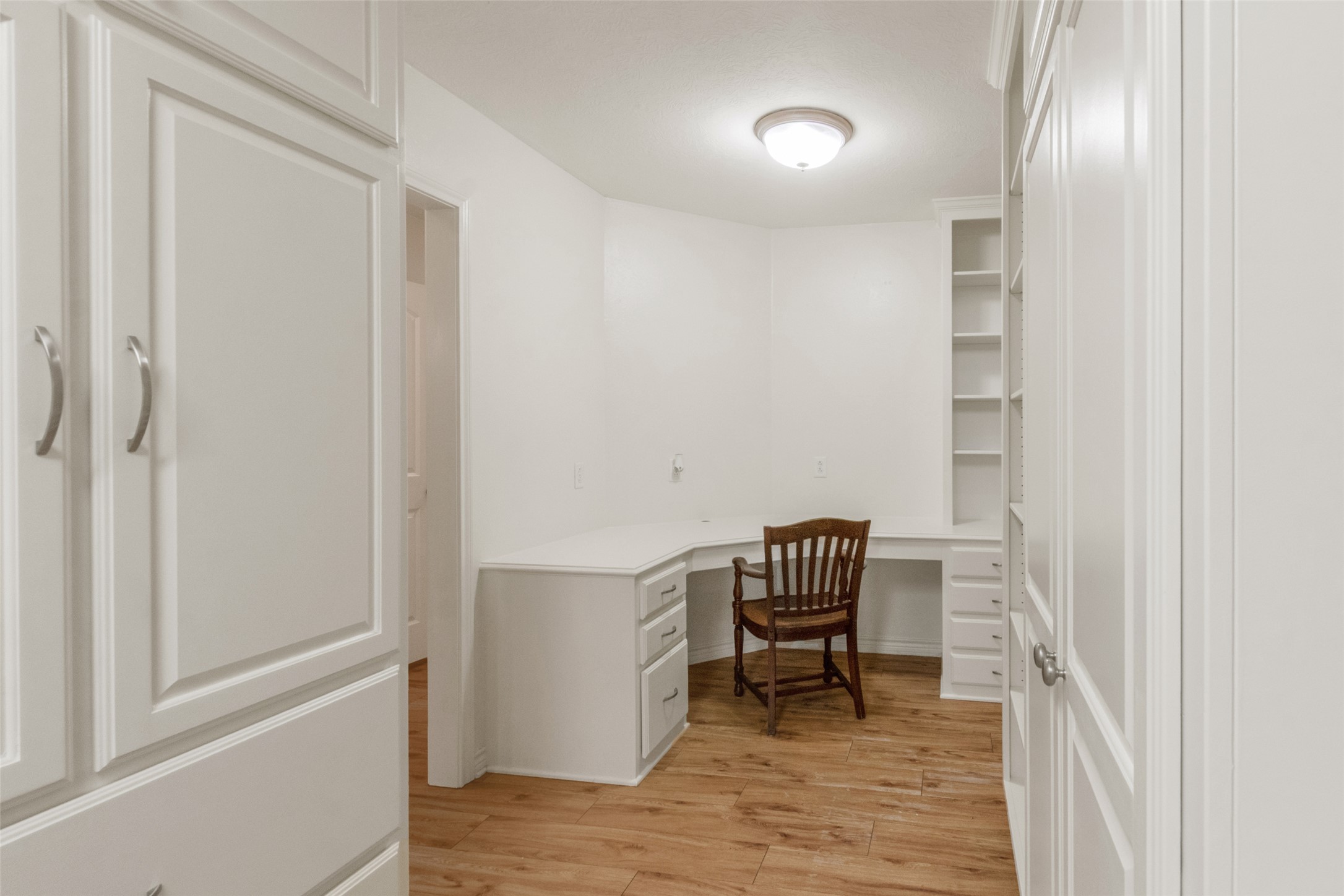9997 Calhoun Road Bryan, TX 77808 - Photo 14 of 28 Custom built-in cabinetry and a built-in desk highlight this versatile workspace with wood flooring.