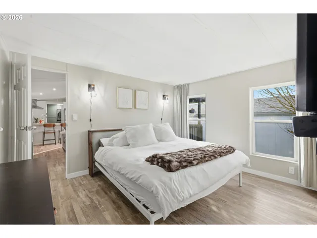 a living room with a bed furniture and a wooden floor