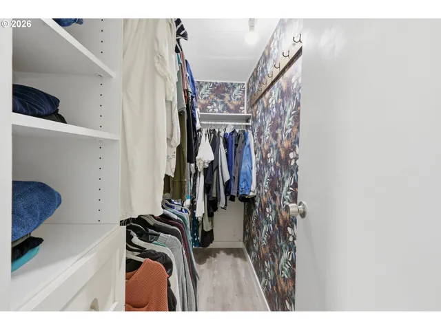 a view of walk in closet with clothes