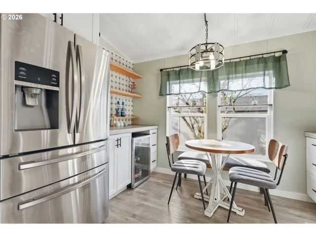 a kitchen with stainless steel appliances granite countertop a kitchen island a table and chairs in it