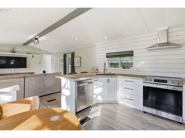 a kitchen with stainless steel appliances kitchen island granite countertop a stove a sink and a microwave