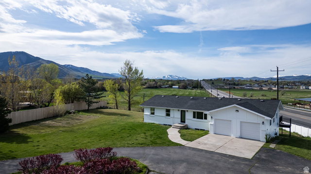 4155 Johnson Road Nibley, UT 84321 - Photo 56 of 71 View of front of house with driveway, a garage, roof with shingles, and a mountain view