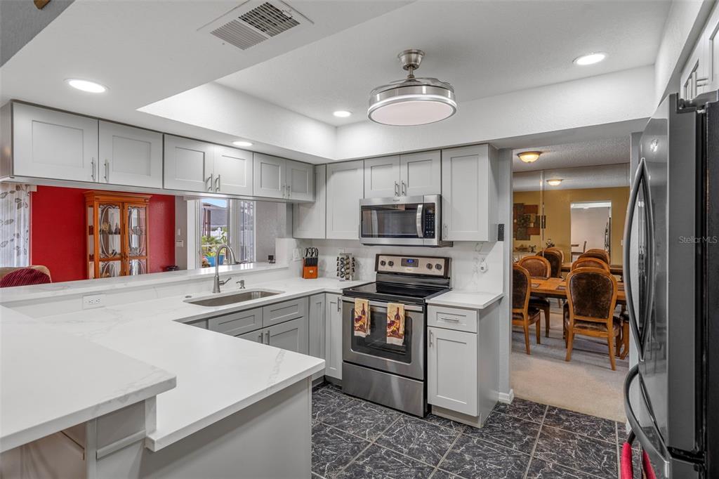 8158 Winding Oak Lane Spring Hill, FL 34606 - Photo 14 of 47 a kitchen with stainless steel appliances granite countertop a sink stove and refrigerator