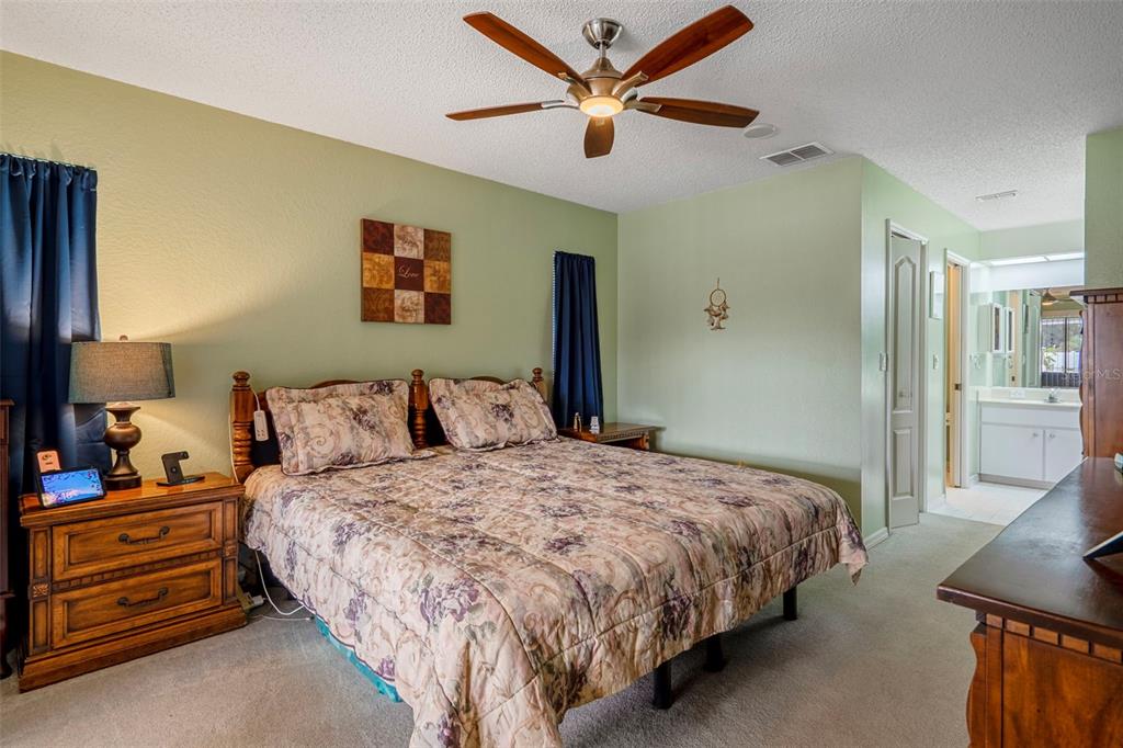 8158 Winding Oak Lane Spring Hill, FL 34606 - Photo 24 of 47 a bedroom with a bed and a chandelier