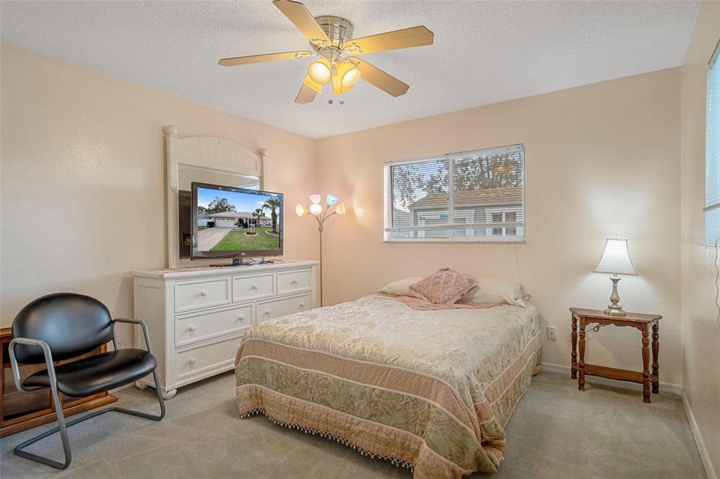 8158 Winding Oak Lane Spring Hill, FL 34606 - Photo 32 of 47 a bedroom with a bed and a chandelier