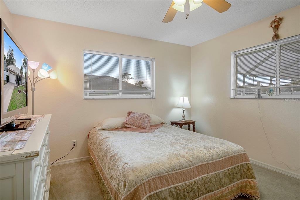 8158 Winding Oak Lane Spring Hill, FL 34606 - Photo 33 of 47 a bedroom with a bed and a chandelier