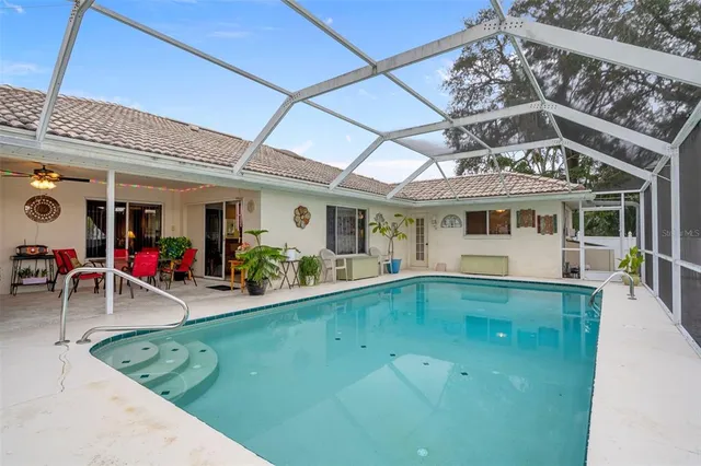 a view of a swimming pool with a patio and plants