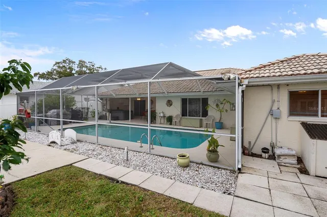 a view of a patio with table and chairs potted plants and a palm tree