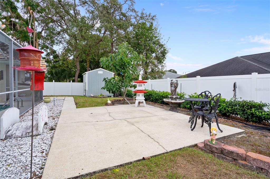 8158 Winding Oak Lane Spring Hill, FL 34606 - Photo 47 of 47 a view of a patio with table and chairs potted plants and a palm tree