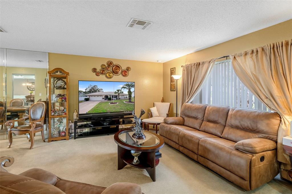 8158 Winding Oak Lane Spring Hill, FL 34606 - Photo 9 of 47 a living room with furniture and a flat screen tv