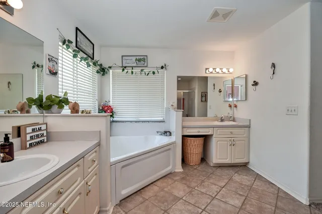 a bathroom with a tub sink and mirror