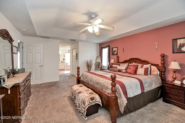 a spacious bedroom with a bed and a chandelier
