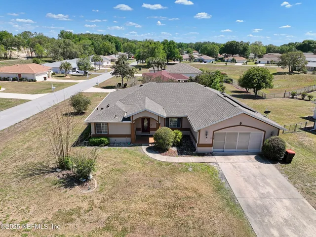an aerial view of a house with a yard and mountain view in back