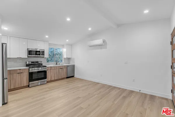 a large kitchen with a stove top oven and refrigerator