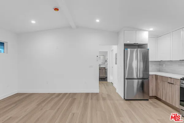 a view of a refrigerator in kitchen and wooden floor