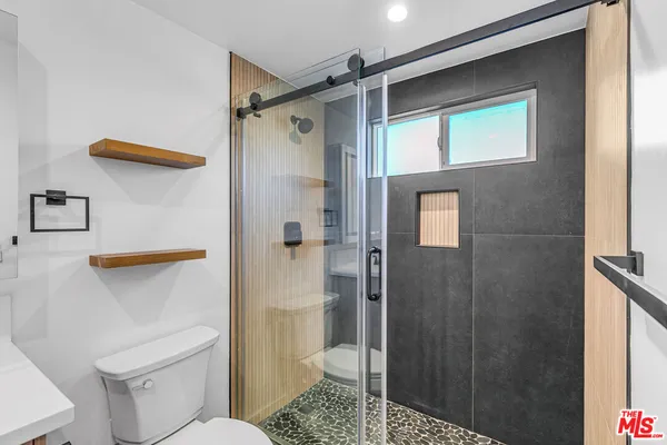 a bathroom with a shower a toilet and a sink